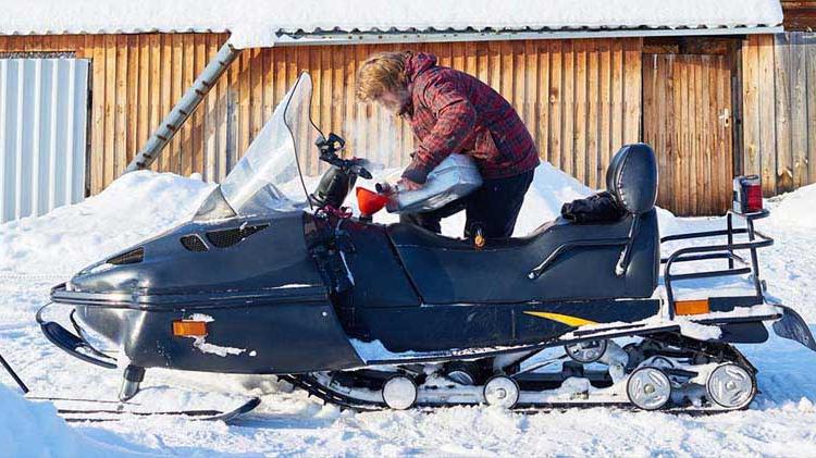 A man unloads his snowmobile.